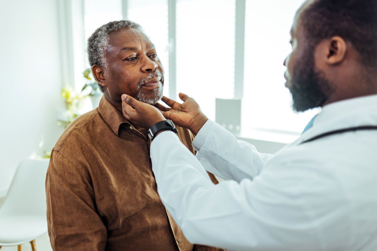 diagnosis for sore throat Doctor feeling a patients throat for symptoms of a sore throat